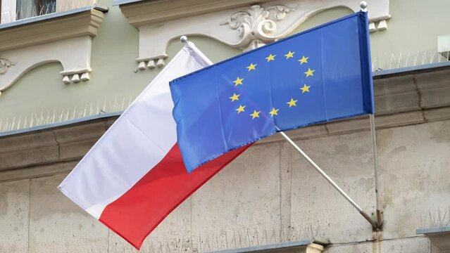 Flags of Poland and the European Union, Polish flag and UE flag together, object closeup, nobody, slow motion. NATO countries alliance protection political treaty symbol abstract concept, no people