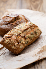 Gold rustic crusty loaves of bread and buns on wooden background. Still life captured from above top view, flat lay.