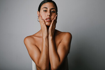 Obraz premium Beautiful young woman with perfect skin posing on white background. Isolated.