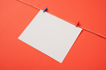 Blank white paper for mockup design with red and blue clips on red background