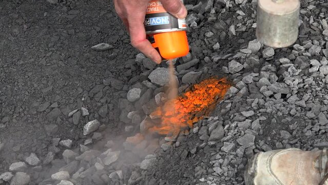Worker marks a spot on asphalt with florescent spray paint with a plumb line adjustment, High quality 4k footage