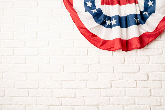 USA national flag on white brick wall background with copy space