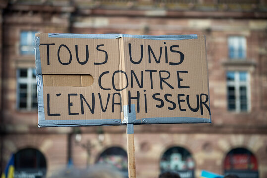 people protesting against the war with text in french : Tous unis contre l'envahisseur, in english : all united against the invader