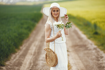 Woman in elegant dress standing in a summer field