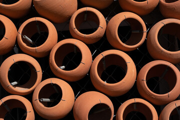 many clay pots stacked together form a beautiful patterned wall.