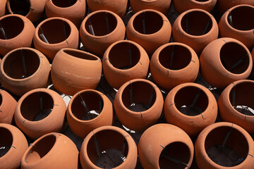 many clay pots stacked together form a beautiful patterned wall.