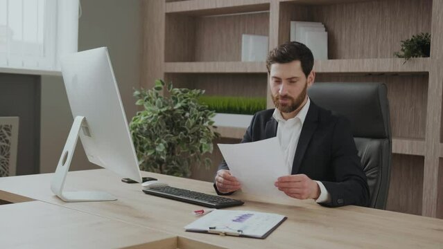 Extremely happy salesman in his office expresses happiness and excitement about the results, sales, analysis, reports. Smart clothing representive good-looking man.