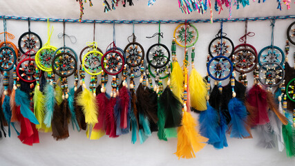 Group of multicolored dreamcatchers with feathers made by hand by indigenous Ecuadorians for sale in an artisan market