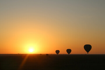 silhouette of three balloons at sunset during a safari in the serengeti