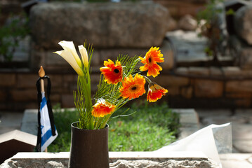 A metal vase with flowers is placed on the grave of a fallen soldier in the Har Herzl military...