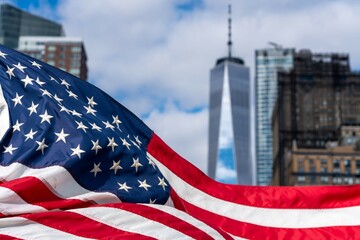 Showing USA flag in front of New Yorker Skyline and sunny day