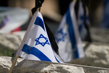 A flag of the State of Israel rests on a grave of a fallen soldier in the Har Herzl military...