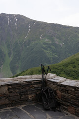 a stone wall corner in the mountains where a mountain climber has left his sticks