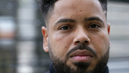 Obraz premium A serious hispanic man portrait face close-up looking at camera