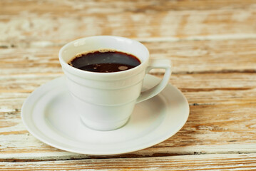 Coffee in a white ceramic mug. Coffee on an old wooden table. Copy space and free space for text near food.