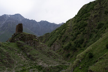 The mountain ranges of Georgia, Kazbegi, where two mountains form a triangular shape and above them a mountain spice that is covered with white snow
