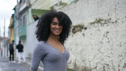 A happy Brazilian woman turning towards camera smiling