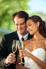Heres to our love. Cropped view of a young bride and groom standing together and toasting their marriage.