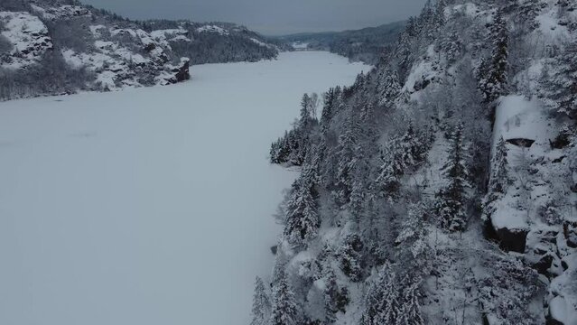 Ascending View from Snow Covered Lake Dingle Dam Mountain Sweden 4K 30fps