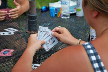 Over the shoulder view of a young woman playing cards