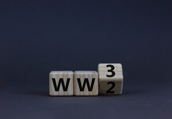 WW3 world war 3 symbol. Turned the wooden cube and changed the concept word WW2 to WW3. Beautiful grey table grey background, copy space. Business WW3 world war 3 concept.