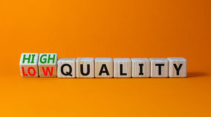 Low or high quality symbol. Turned wooden cubes and changed words low quality to high quality. Beautiful orange table orange background. Business low or high quality concept, copy space.
