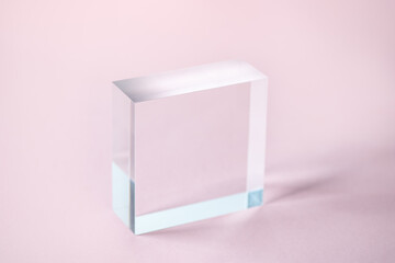 Acrylic Solid Display Block for Shop Windows on pink background, empty podium for product presentation, geometric stand for cosmetics