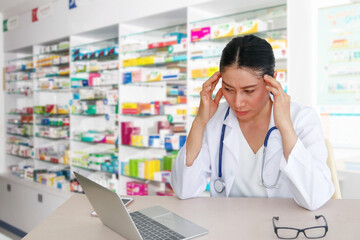 The female doctor sat stressed and tired in the hospital dispensing room.