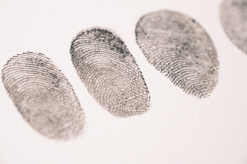 different black fingerprints on a paper close up ,