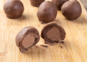 Filled chocolate candy with candies over wooden board