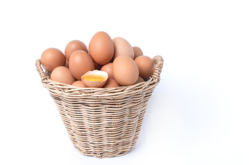 Fresh eggs collected inside wicker basket and one broken, suitable as a food ingredient. Fresh eggs from quality organic farms isolated on white background. Healthy food concept