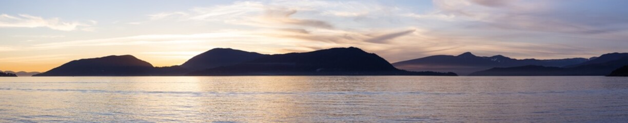 Naklejka premium Panoramic View of Canadian Nature Mountain Landscape on the Pacific Ocean West Coast. Colorful Winter Sunset. Taken in Howe Sound near Horseshoe Bay, West Vancouver, British Columbia, Canada.