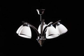 Modern lamp, chandelier on a black background. Lighting element of the interior.