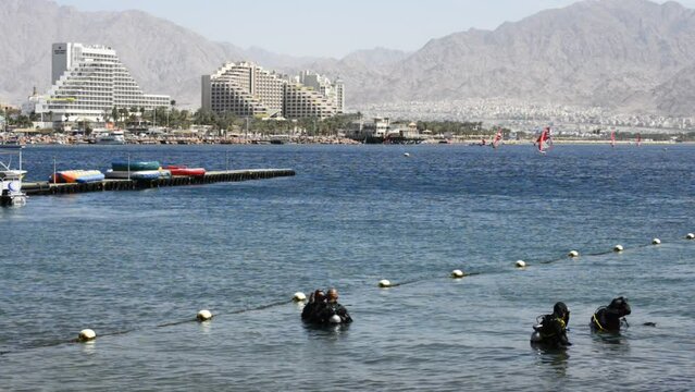 Divers prepare for underwater dive on coral reef near Eilat – famous tourist resort and recreational Israeli city, located on the Red Sea