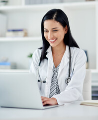 As efficient as youd want your doctor to be. Shot of a young doctor using a laptop at her desk.