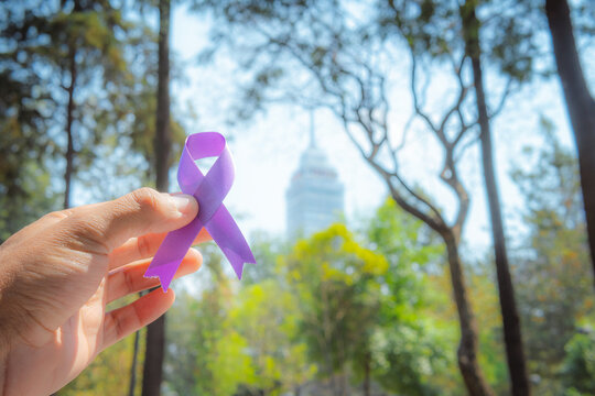 Adult hands with purple ribbon, Alzheimer's disease, Pancreatic cancer, Epilepsy awareness, World Cancer Day