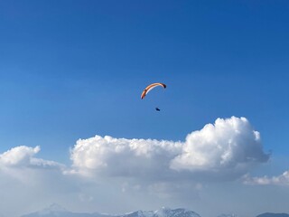 paraglider in the sky with some clouds in the background