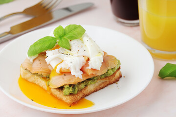 Breakfast with a sandwich with poached egg and avocado	