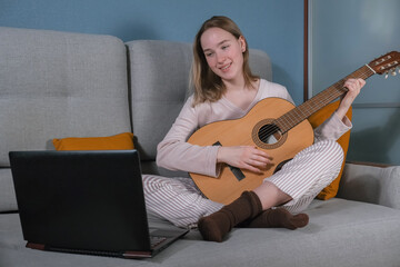 teenager girl plays the guitar at home. Hobby, distance learning, work. Music, mental health, relaxation, meditation.