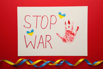 Inscription Stop war with baby handprint on red background, conflict between Ukraine and Russia. No war, stop war, russian aggression. Ukrainian patriot.