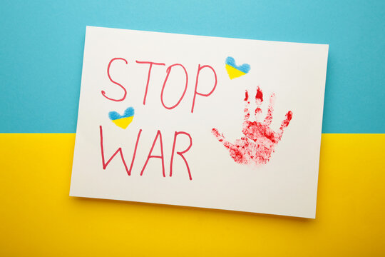 Inscription Stop war with baby handprint on blue - yellow background, conflict between Ukraine and Russia. No war, stop war, russian aggression. Ukrainian patriot.