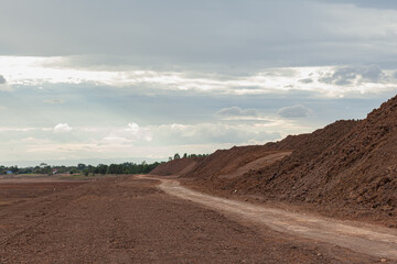 Fototapeta na wymiar A brown soil path beside a newly excavated reservoir.