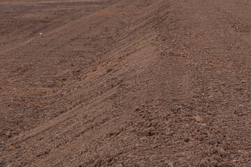 A red dirt road beside a newly dug clay dam.
