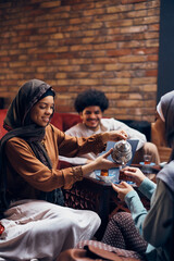 Young Middle Eastern woman pours Turkish tea to her female friend.