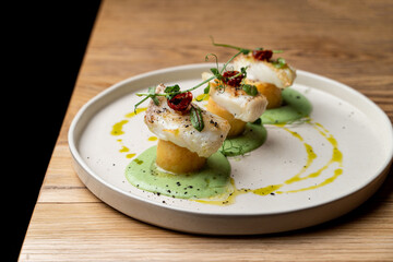 Fine dining cod with baked potato and avocado cream