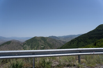 view of a large crop field from the highway where you can see the roadside barrier