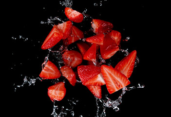 Freeze motion of sliced strawberries in water splash.