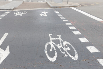 Bicycle path, markings on the asphalt. Gray cracked asphalt in the city