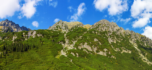 Panorama szczytów Wielki Wołoszyn, Pośredni Wołoszyn i Skrajny Wołoszyn, skaliste szczyty pod błękitnym niebem, Tatry polskie