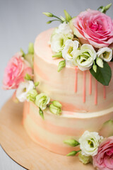 Tiered cake with fresh flowers and macaroons